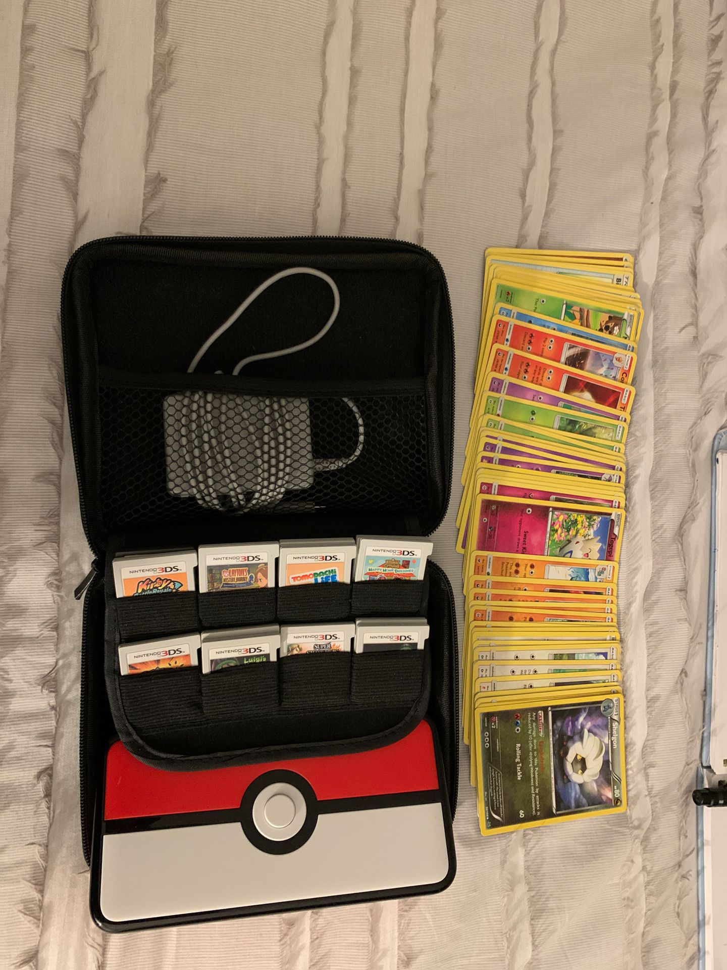 Nintendo 3DS, 14 games, case, and 50 Pokémon cards