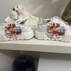 These appear to be from Versace, featuring a white leather base + bold floral print and a chunky sole. A very close match in style is the model