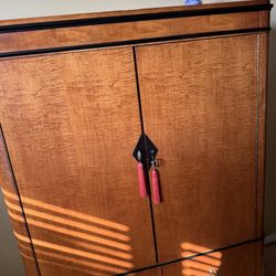 Biedermeier-style armoire featuring curly maple wood with ebonized trim