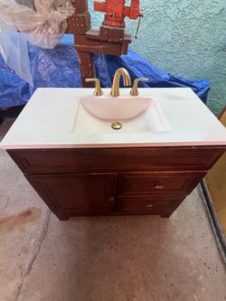 Single Sink Bath Vanity in Dark Cognac with Arctic Solid Surface Top with brushed gold faucet.