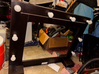 Woman’s vanity mirror with storage behind it.