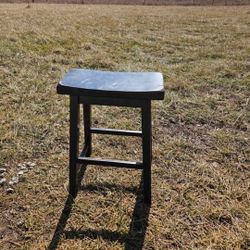 black wooden saddle seat bar stool
