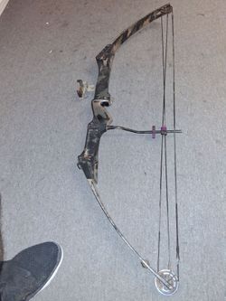 This is a vintage compound bow used for archery and bowhunting.Specifically, the design characteristics—such as the distinct camo-patterned metal rise