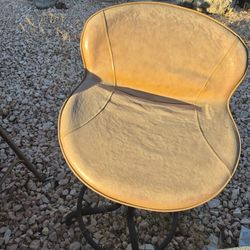 adjustable height swivel bar stool with a low back and a brown faux leather seat
