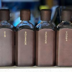 A set of 4 20th Century English Leather Wrapped Glass Liquor Bottles By Albro