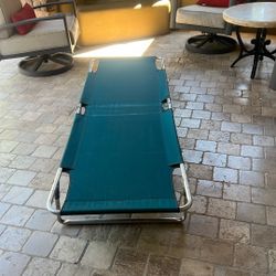 Sportman’s King Size On green, aluminum-framed folding camping cot, similar to models manufactured by Coleman or Kemp USA