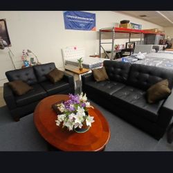 NEW SOFA AND LOVESEAT APARTMENT SIZE. BLACK FAUX LEATHER WITH BROWN ACCENT PILLOWS 