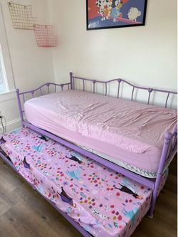 Purple metal frame bed with trundle