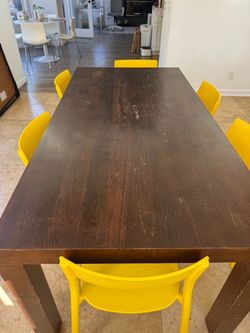 CB2 Dark Wood Dining Table with Yellow Chairs