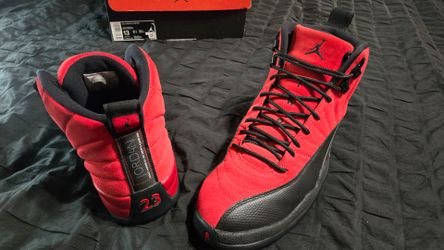 Air Jordan 12 Retro "Reverse Flu Game" features a vibrant varsity red suede upper contrasted with a black pebbled leather mudguard  (size 13)