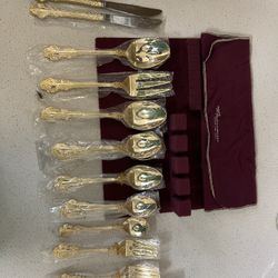 of gold-plated flatware in a burgundy storage case. This type of cutlery is typically electroplated with 23K gold over a stainless steel base.  The se