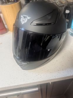 Large full face matte black motorcycle helmet.