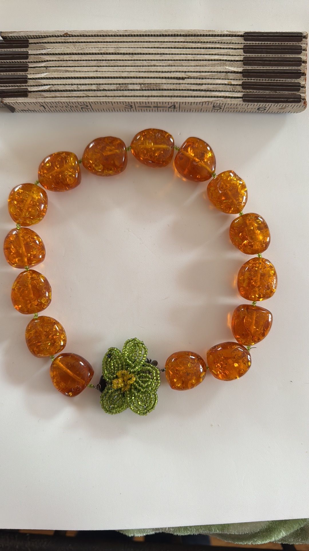 Unique and striking design: amber like beads with a beaded floral centerpiece