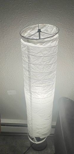 Over the toilet a storage and floor lamp