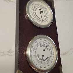 Barometer and thermometer with hygrometer on a mahogany wood base. Measures 12.5 inches high x 6 inches wide