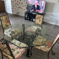 Forged table with glass top plus four wrought iron chairs ⁠