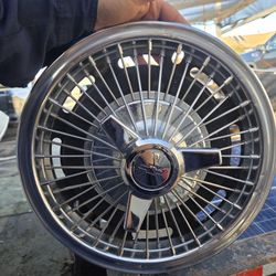 Chevrolet wire spoke spinner hubcap, commonly used on models such as the Chevy II, Corvair, or Impala from the mid-1960s. 