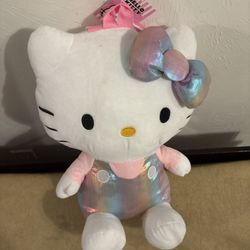 ✨ This super cute Hello Kitty plush backpack with its iridescent rainbow bow and overalls 