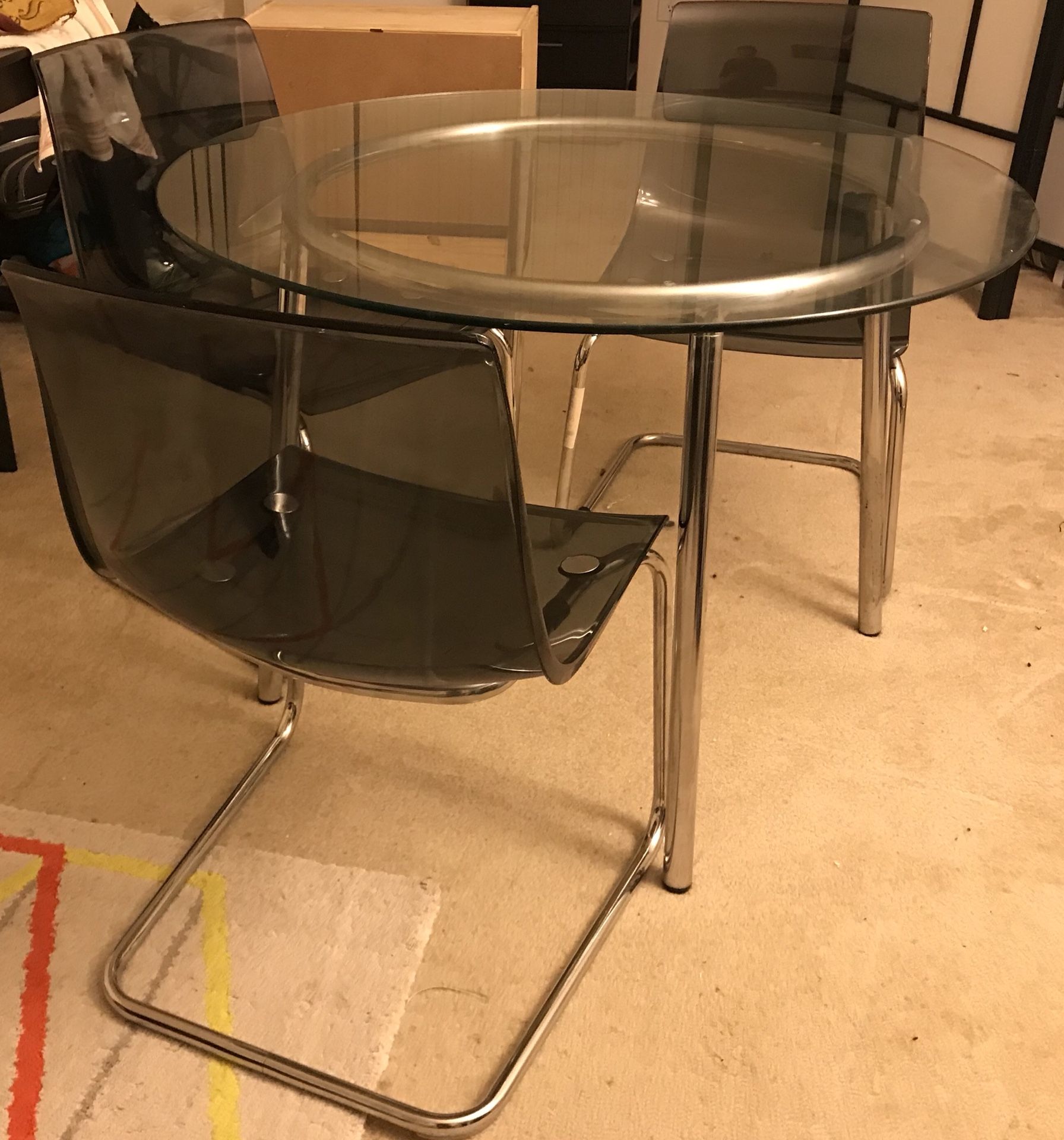 Glass/metal dining room set. Includes glass table top, metal table frame, and 3 chairs.