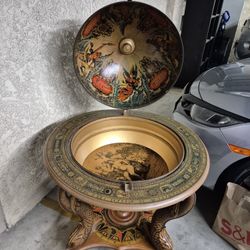 Description:
Globe high top drinks cabinet standing on a turned center support with carved Dolphins to each corner on castors 120x85cm