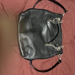 Coach Stylish black leather handbag with chain straps.
