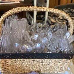 Plastic silverware, forks, spoons, and knives in a wicker basket
