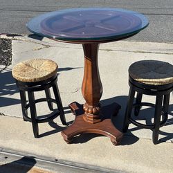 Glass top table with two stools.