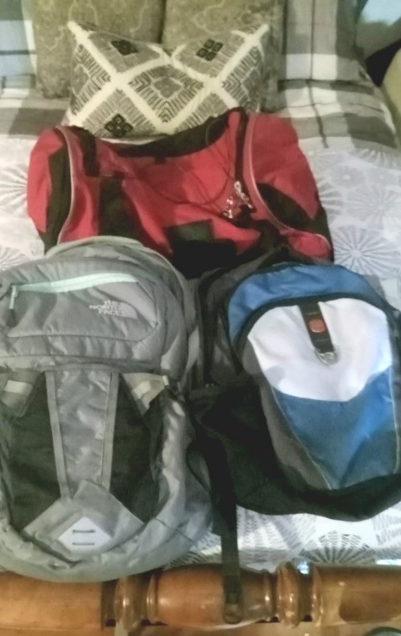 North Face Backpack, Swiss Gear, and Protege Barrel Bag.