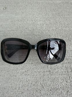 Authentic DKNY sunglasses, model DY 4073 3001/11. Features a glossy black oversized frame with dark tinted lenses and DKNY logo accents on both temple