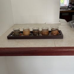 Five Piece Candles Decorated With Energy Stones On Wood Tray