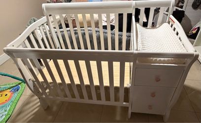 White baby crib with drawers and changing station