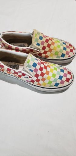 Vans Classic Slip-On sneakers feature a vibrant, rainbow checkerboard pattern across the canvas upper