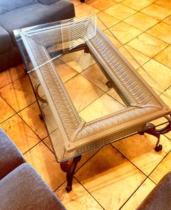 lass-top coffee table with ornate metal base