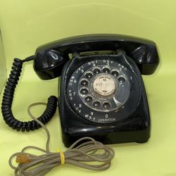vintage 1970s automatic electric phone with a black rotary dial, 