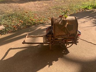 Vintage handmade decorative wooden cart features rustic twig construction, a curved bark-textured cover, and decorative faux red chili peppers on top.