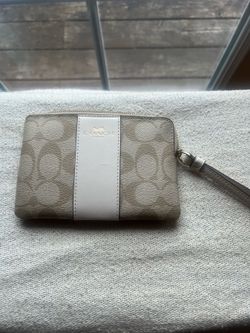 Coach Corner Zip Wristlet in Signature Canvas with a beige and white stripe design.