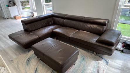 modern brown leather L-shaped sectional sofa features adjustable ratchet headrests and a matching ottoman