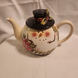 TIl Collections Poinsettia Ceramic Snowman
Teapot
Snowman and poinsettia on the front, larger
poinsettia on the back. Adorable top hat closure.
The pe