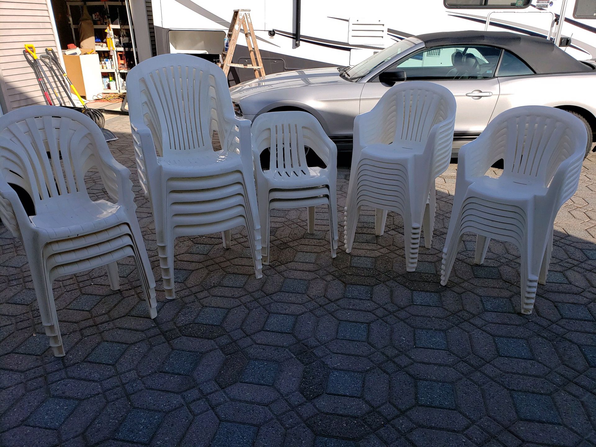 Resin white patio chairs (six with high backs) the remaining 24 are regular size.