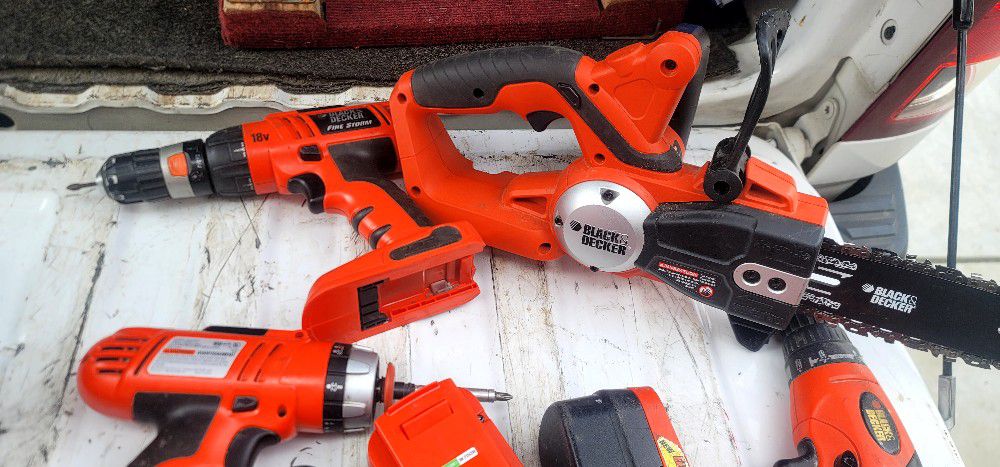 three Black & Decker drills one chainsaw three batteries and charger 