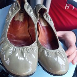 These are likely Prada women's metallic leather driving loafers. This style of flat, slip-on shoe is characteristic of the Prada brand, featuring a me