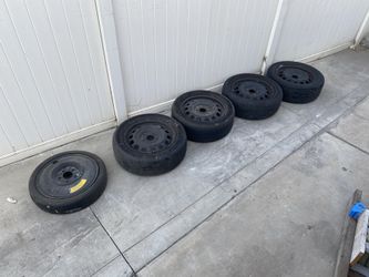 Four full size rims and tires, and one spare rim