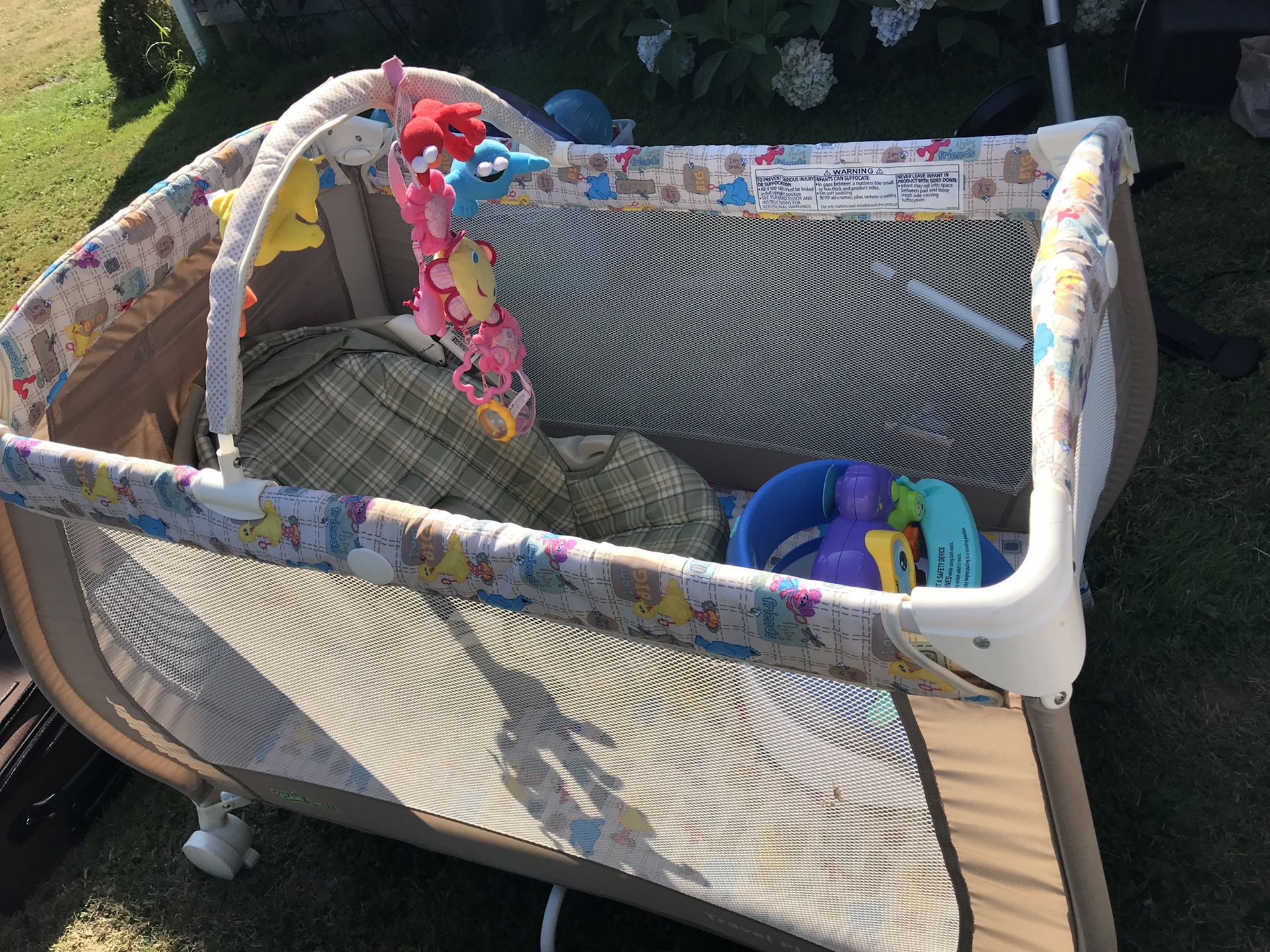 Crib, car seat, and a chair with toys attached