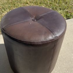 Selling a brown faux-leather ottoman.