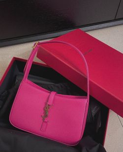 Bright pink, smooth leather crossbody bag with golden logo, luxurious style, women's retro type shoulder bag at the armpit