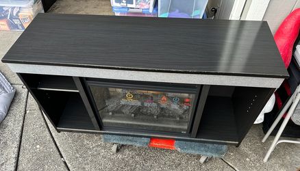 black TV stand with a built-in electric fireplace insert