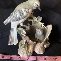 figurine is a porcelain piece titled "Gentle Beginnings Mockingbirds" by Homco, likely produced in 1994. It depicts a mother mockingbird watching over