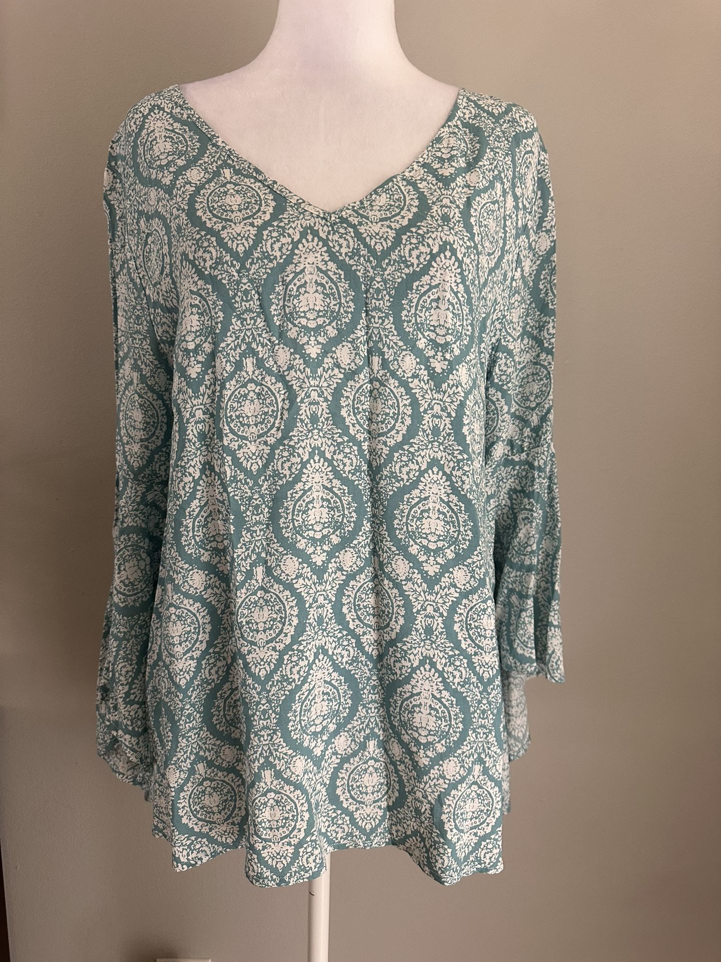 The NWT Entro Print Bell Sleeves Top is a bohemian-inspired blouse in a beautiful blue color. Featuring a V-neck and cross-back detail, this long slee