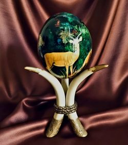 African safari-themed decoupage/painted ostrich egg on a faux horn tusk display.