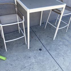 Outdoor patio set includes table and 2 bar stools. 